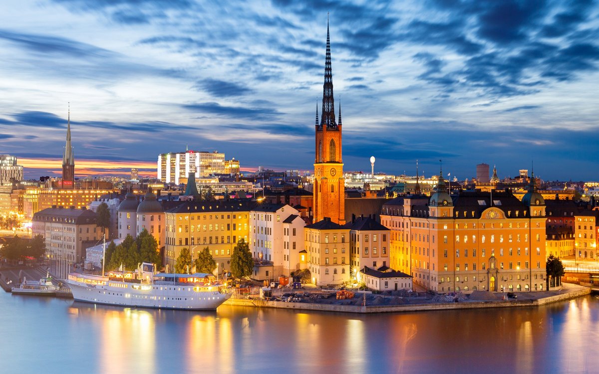 Riddarholmen in Stockholm at dusk with the church spire reflected in the water